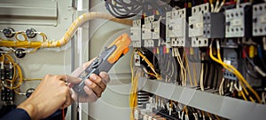 Electrical engineer using measuring equipment to checking electric current voltage at circuit breaker and cable wiring system ,