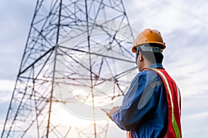 Electrical engineer wear safety clothes standing and watching at the electric power station to view the planning work by producing