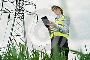 electrical engineer woman high voltage power industry, electrician worker working, energy concept, high voltage electrical tower,