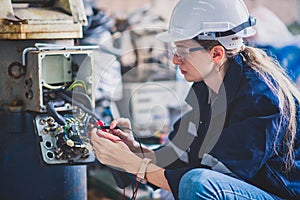 Electrical engineer work tester measuring voltage and current of power electric line in electrical cabinet control for industrial