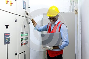 Electrical engineer working in control room. Electrical engineer man checking Power Distribution Cabinet in the control room