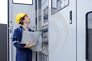 Electrical engineer working in control room. Electrical engineer man checking Power Distribution Cabinet in the control room