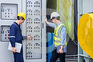 Electrical engineer working in control room. Electrical engineer man checking Power Distribution Cabinet in the control room