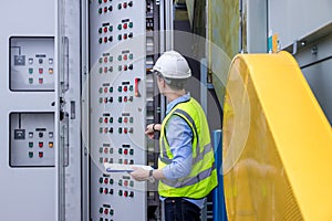 Electrical engineer working in control room. Electrical engineer man checking Power Distribution Cabinet in the control room