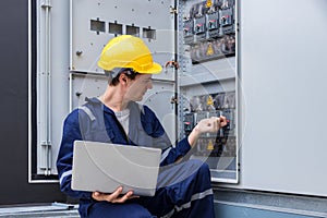 Electrical engineer working in control room. Electrical engineer man checking Power Distribution Cabinet in the control room