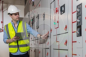 Electrical engineer working in control room. Electrical engineer man checking Power Distribution Cabinet in the control room