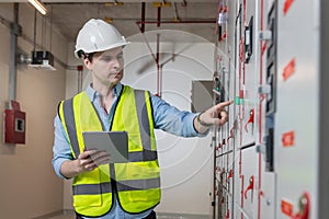 Electrical engineer working in control room. Electrical engineer man checking Power Distribution Cabinet in the control room