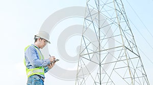 Electrical engineer working on digital tablet with electric power pole