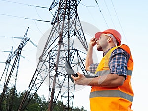 Electrical engineer working. Talking on the phone and working working on a laptop