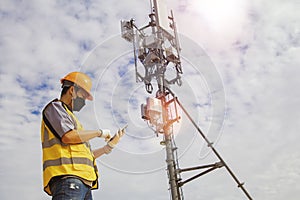 Electrical engineers work on telecommunication. tower.lj.Helmets and safety equipment use smartphones near the signal towers tall