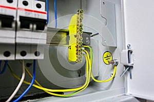 Electrical ground wires is connected to ground copper bar or earth bonding bar in metal electric breaker box with photo