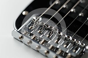 Electrical guitar bridge and metal strings closeup. Electric guitar black and white color, detail. Music instruments