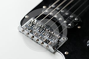 Electrical guitar bridge and metal strings closeup. Electric guitar black and white color, detail. Music instruments