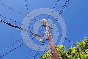 Electrical installation in the USA. Oil transformers on a wooden pole. If mounted on a utility pole, they are called pole-mount