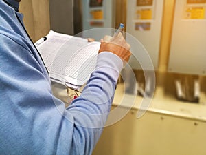 Electrical or Instrument technician checking electrical control cabinet in heavy industry plant, maintenance and service concept