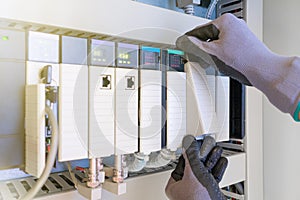 Electrical and Instrument technician replacing input and output card of programable logic controller PLC for oil and gas process