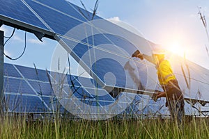 Electrical and instrument technician use battery drill to maintenance electric system at solar panel field photo