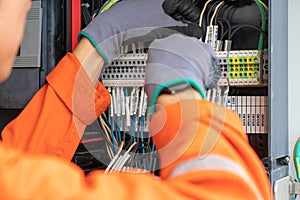 Electrical and instrument technician wiring cable at terminal and junction box.