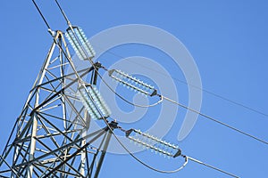 Electrical insulator on a power tower on blue sky