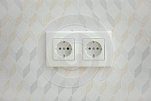 Electrical jack white plastic socket on a white wall