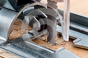 An electrical jigsaw cutting through chip board. Blurred background