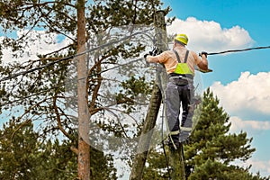 Electrical lineman connecting wires high on electric pole. powerline maintenance and repair