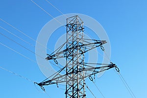 Electrical network of high voltage. Transportation of electricity through the high-voltage line. Metal tower with wires and cables