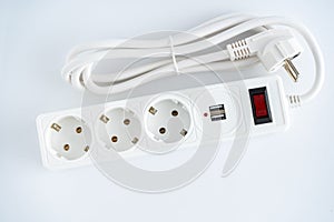 Electrical outlet extension cord. White cable with USB connector for charging phones. Electrical appliance. White