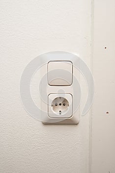 An electrical outlet and light switch on a wall