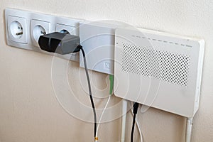 Electrical outlets and internet modem on a cream wall background photo