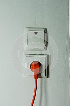Electrical plug, electrical outlet and switch on a white wall