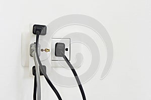 Electrical plug and socket overloaded on white background, copy space