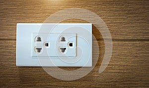 Electrical plug socket on wooden wall