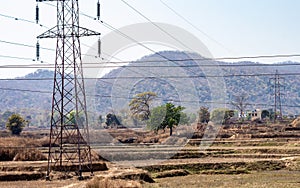 Electrical Pole installation in the fields of Chota Nagpur Plateau against mountain in the background. Ramgarh Jharkhand India