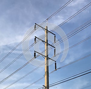 Electrical pole with power lines against blue sky