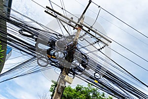 An electrical pole that shows the disorder in the arrangement of the cables.