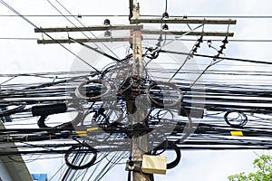 An electrical pole that shows the disorder in the arrangement of the cables.