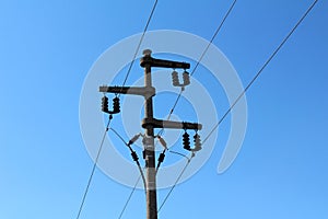 Electrical power line utility pole made of strong concrete with multiple ceramic insulators connecting and holding wires