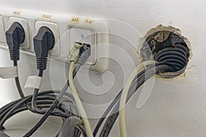 Electrical power outlets with multiple plugs and cables connected to a wall socket