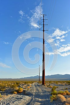 Electrical power poles and power lines along dirt road Pahrump, Nevada, USA