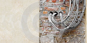 Electrical power and telephone cables against a brick and plaster wall - image with copy space