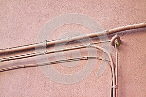 Electrical power and telephone cables against a plaster wall