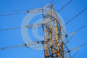 Electrical power tower at sunset with orange metal