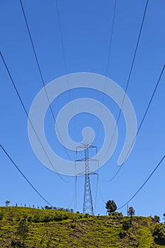 Electrical Powerlines on a Hill before a Blue Sky photo