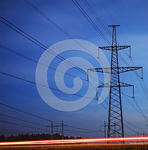 Electrical pylon and high voltage power lines at night.