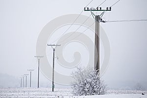 Electrical pylons high voltage wires in winter covered snow