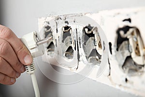 Electrical short circuit, dangerous use of electricity. Damaged socket in the wall