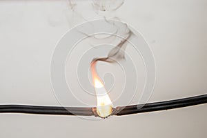 Electrical short circuit. Wiring cable on fire flame