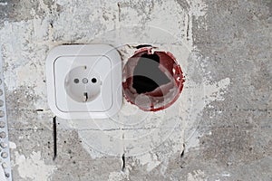 Electrical socket hole on concrete wall. Under construction electrical socket close up