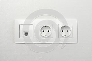 Electrical sockets on the wall with black connection internet plug and white wire. Socket set with usb cord and electricity cable